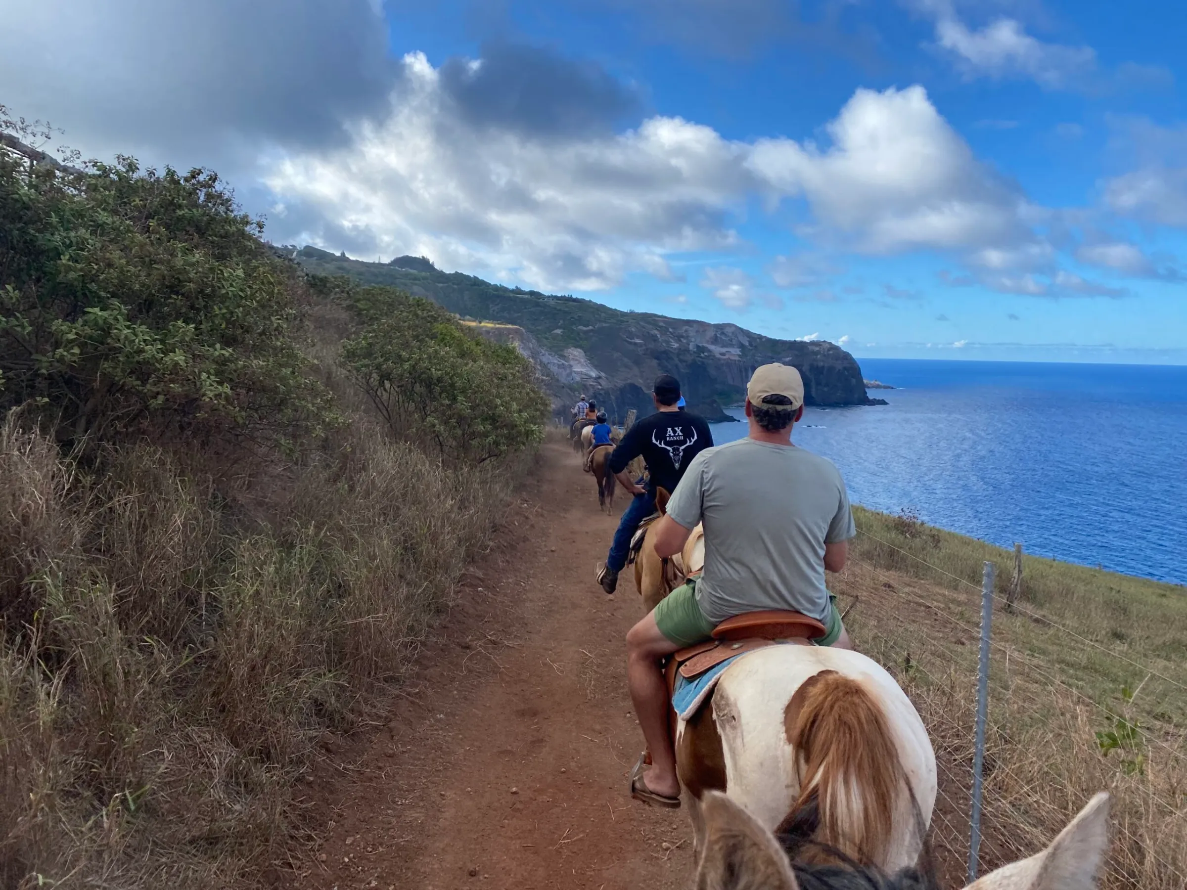 a man riding a horse on a dirt road