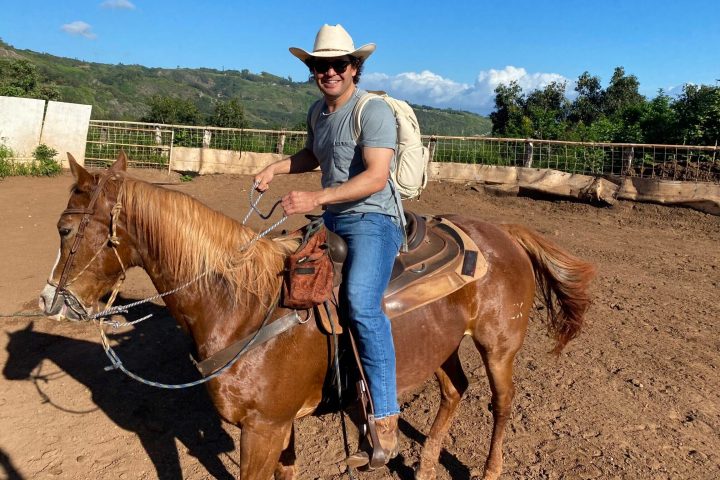 a man riding a horse in a dirt field