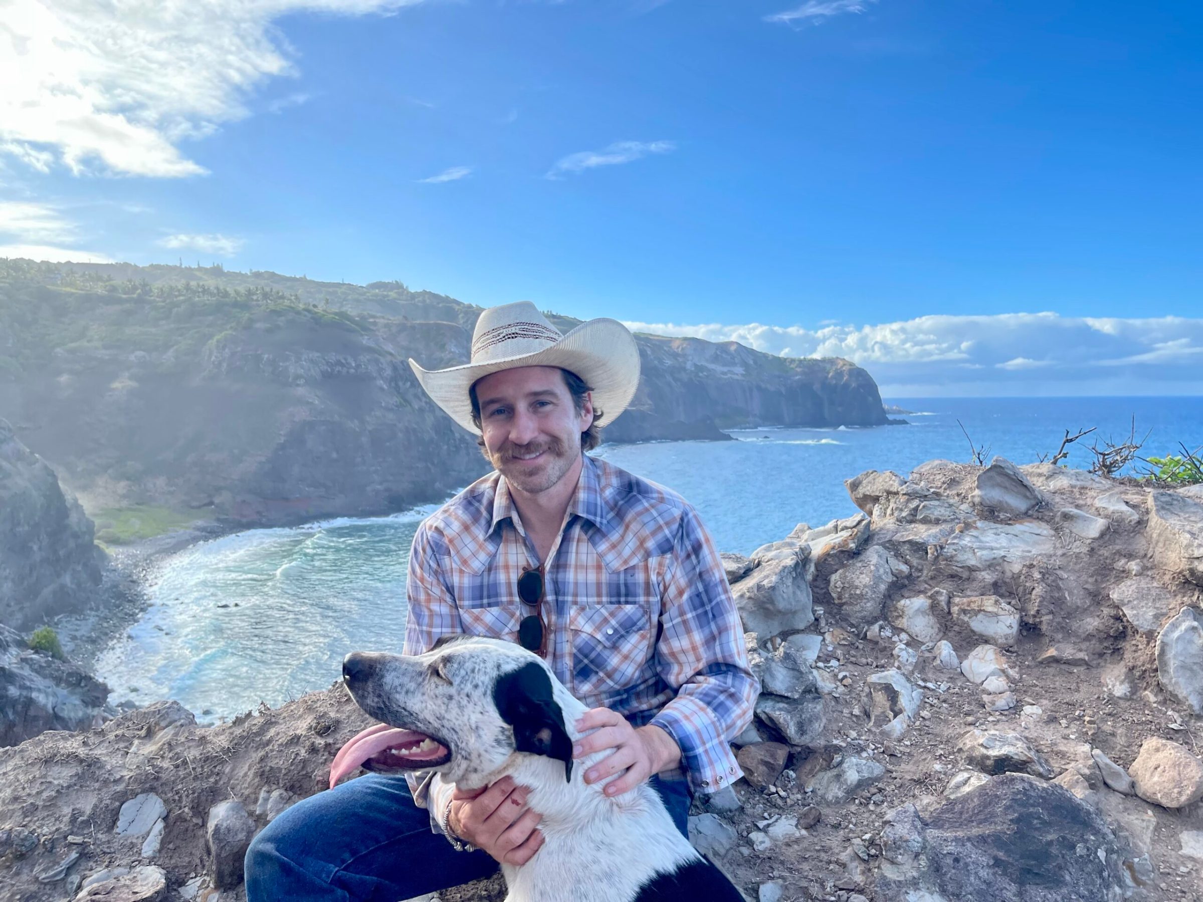a person holding a teddy bear sitting on a rock
